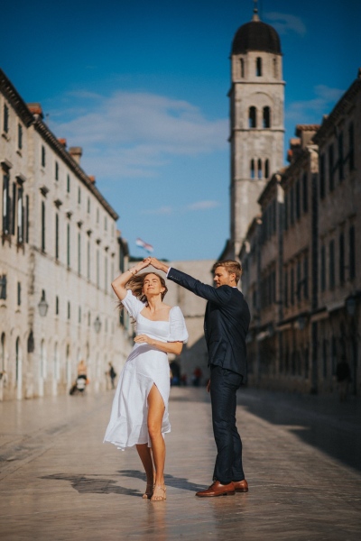 Portrait of a dancing couple at Stradun main Street in the Old town of Dubrovnik, morning light