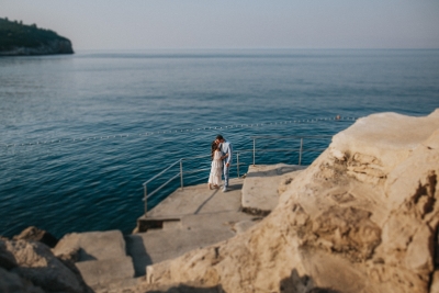 Portrait of a couple taken at Buza beach in the morning. Morning light, sea and island of Lokrum in the background