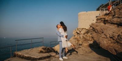 Portrait of a couple taken at Buza beach in the morning. Morning light, sea and island of Lokrum in the background