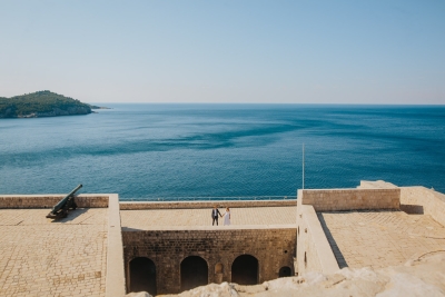 St. Lawrence fortress in Dubrovnik, panoramic view in the morning. Couple on a photo shoot. Sea, sky and island of Lokrum in background