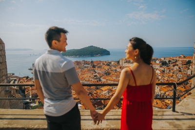 Portrait of a couple at Minceta tower, view over the island of Lokrum, Old town red roofs, blue sea and sky. Game of Thrones filming location