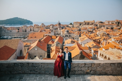 Dubrovnik City Walls in the morning, Old town red roofs, island of Lokrum and sea in the background. Photo shoot with a beautiful couple. Red dress, Game of Thrones