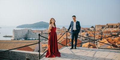 Dubrovnik City Walls in the morning, Old town red roofs, island of Lokrum and sea in the background. Photo shoot with a beautiful couple. Red dress, Game of Thrones